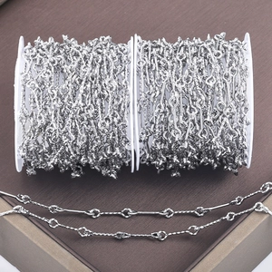 Polished stainless steel bamboo link chain on a wooden display for DIY jewelry making