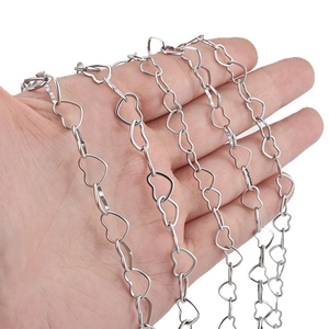 Minimalist silver stainless steel heart link chain necklace shown held in hand