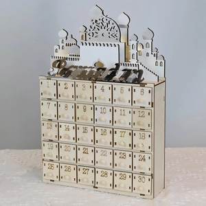 Detail of wooden Ramadan countdown calendar with 30 small drawers and LED mosque silhouette