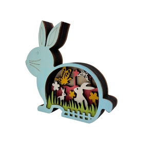 Detail of multi-layered wooden Easter bunny craft with intricate forest scenes and flowers