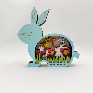 Detail of multi-layered laser-cut wooden rabbit decor featuring a natural spring scene