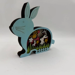 Macro side view of laser-cut multi-layer wooden Easter bunny with garden landscape