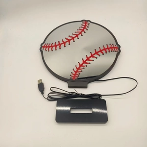 Detail view of baseball-shaped LED night light with mirrored panel and USB base power cord