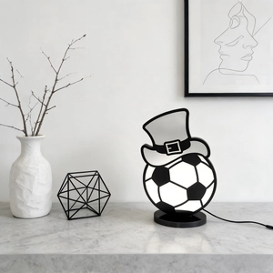 Creative soccer ball desk lamp with black top hat on a modern marble table setting
