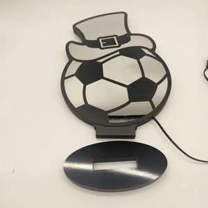 Detailed view of football LED night light with black base and USB cable on white background