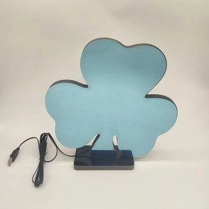 Macro detail of clover-shaped acrylic light with USB cable and black base