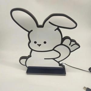 Front view of cartoon bunny LED desk lamp with carrot and USB cable on black base