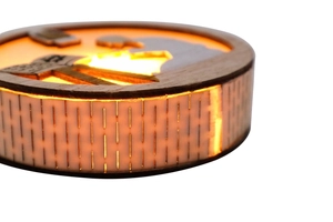 Close-up of wooden night light with glowing LED warm light and intricate hollow pattern
