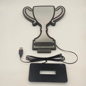 Detail of trophy-shaped LED neon lamp with black base and USB cable for home decor