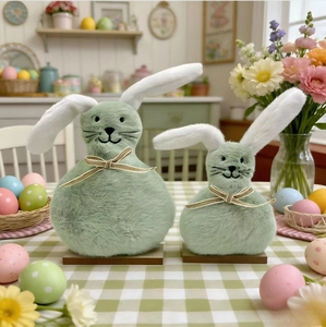 Detail of plush Easter bunny figurines with gold ribbons on wood bases in a cozy setting