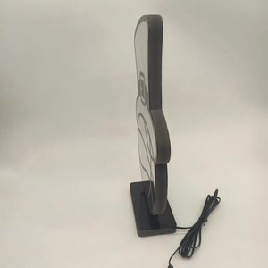 Macro side view of a minimalist cartoon LED lamp with sleek black base and acrylic board