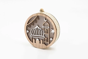 Detail of laser-cut wooden Ramadan ornament with mosque and crescent moon design