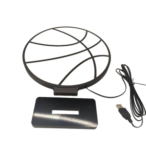Creative basketball-shaped LED bedside lamp with black base and USB cable on white background