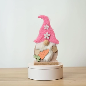 Handmade Easter gnome featuring a pink felt hat and a wooden carrot on a square base