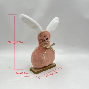 Pink plush Easter bunny figurine with long white ears and bow on a wooden base