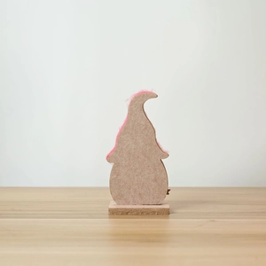 Detail of Easter gnome gnome decor with gray felt and pink accents on wooden base