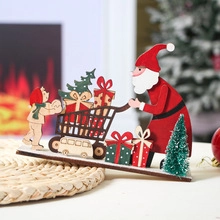 Close-up of wooden LED Christmas house with Santa Claus and festive tree decoration