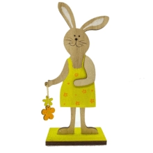 Detail der Osterhasen-Holzfigur mit gelbem Blumenkleid auf grünem Sockel