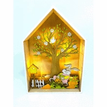 Detail of wooden bunny house lamp featuring a blossoming tree and warm LED light scene