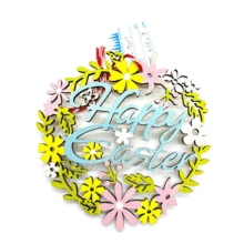 Detail eines hölzernen Osterkranzes mit bunten Blumen und einer Aufhängeschnur