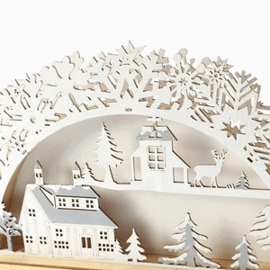 Close-up of laser-cut wooden Christmas bridge with intricate deer and village details