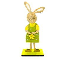 Detail der hölzernen Osterhasenfigur mit gelbem Hemd, grüner Schürze und Blumenakzent