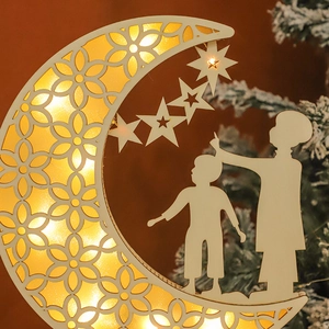Detail of wooden crescent moon LED light with hollow floral patterns and warm glow