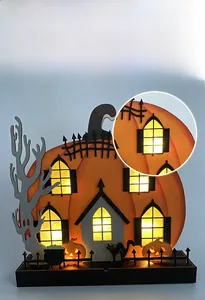 Detail of wooden Halloween pumpkin house with LED lights showing glowing windows and black cat
