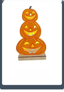 Close-up of three stacked wooden Halloween Jack-O'-Lanterns with warm LED glowing effect