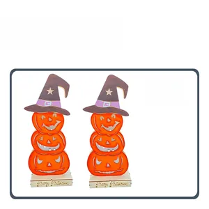 Detail view of stacked wooden pumpkin ornaments with wizard hats and Happy Halloween base