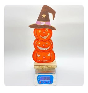 Detailed view of layered wooden Halloween pumpkin decor being weighed on a digital scale