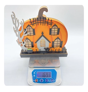 Detailed view of an illuminated Halloween pumpkin wooden house showing weight of 169.3g