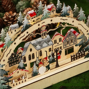 Detail of wooden Christmas LED bridge lamp showing laser-cut forest scene and warm lights