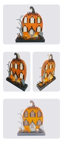 Detail of wooden pumpkin haunted house silhouette with warm LED lights and Halloween motifs