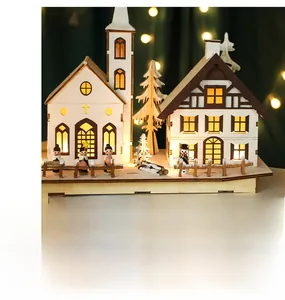 Close-up of wooden Christmas village ornament with LED lights and festive snowy trees