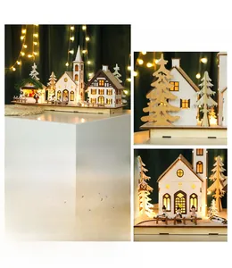 Detail of wooden Christmas village ornament featuring LED glowing church and snowed pines