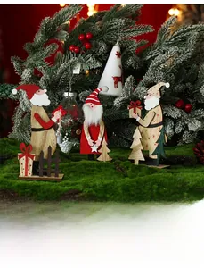 Close-up of wooden Santa figurines with felt accents on a festive moss background