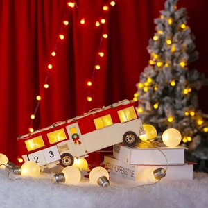 Illuminated red and white wooden Christmas bus calendar with LED lights on a snowy rug