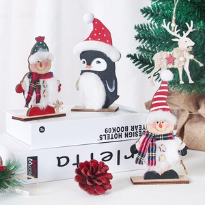 Close-up of wooden Christmas ornaments with snowman, penguin, and reindeer details