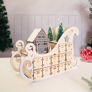 Detailed view of a wooden sleigh advent calendar with small numbered drawers and snow scenery