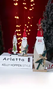 Vue détaillée de trois figurines de Père Noël en bois sur des livres décoratifs