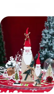 Trio de figurines Père Noël en bois avec cloches rustiques et détails de sapin vert