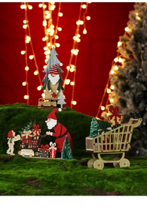 Macro shot of painted wooden Christmas ornaments including Santa and trees on moss base
