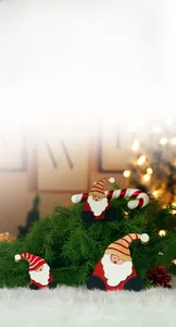 Close-up of three wooden Santa Claus ornaments with striped hats and candy canes