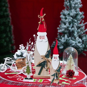 Three-piece wooden Santa figurines set with bells and mini tree details on red background