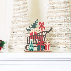 Detail of wooden Christmas cart ornament with red gift boxes and green tree on white surface
