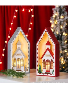 Close-up of wooden Christmas house lamp with warm LED church model and X-mas detail