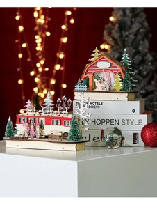 Detail of wooden Christmas house and vintage car models with warm LED lights