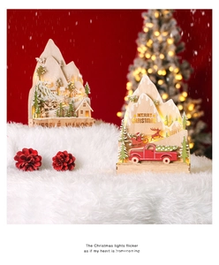 Close-up of lighted wooden Christmas mountain scene with warm LED lights and Santa motifs