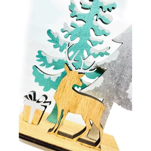 Close-up of wooden Christmas tree and reindeer desk decor with glitter and laser-cut details